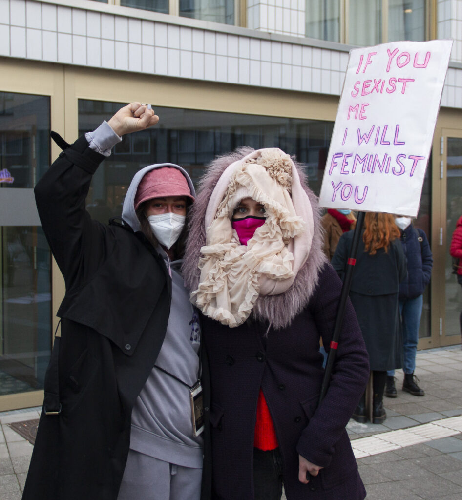Zwei Protestierende mit einem Plakat