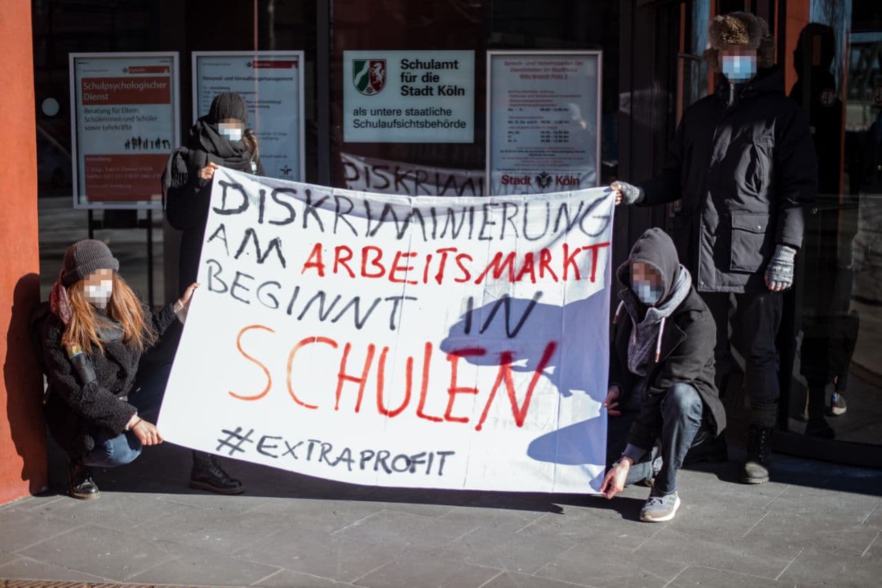 Demonstrierende halten ein Plakat gegen Diskriminierung an Schulen