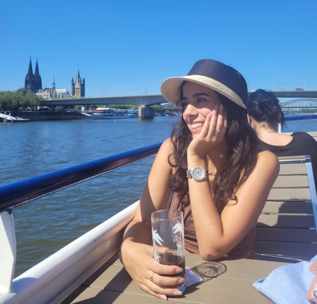 Portrait einer Person auf einem Boot. Im Hintergrund eine Brücke und eine Kirche.